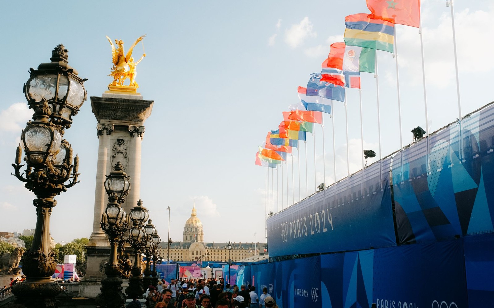 National flags line the Pont Alexandre III near Paris 2024 Olympic signage and ornate lamp posts