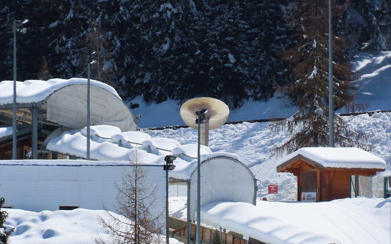 The La Plagne bobsleigh and luge track seen along its length from outside the refrigerated concrete channel, the Tarentaise valley visible below